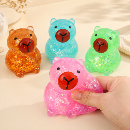 Four gel capybara colors with a hand squeezing the pink figure