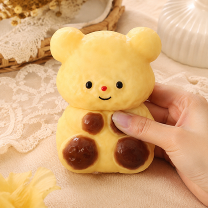 Hand pressing a caramel bear sensory squeeze toy