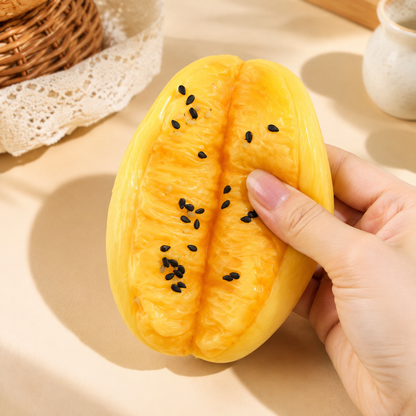Hand pressing a golden double-lobe youtiao sensory squeeze toy