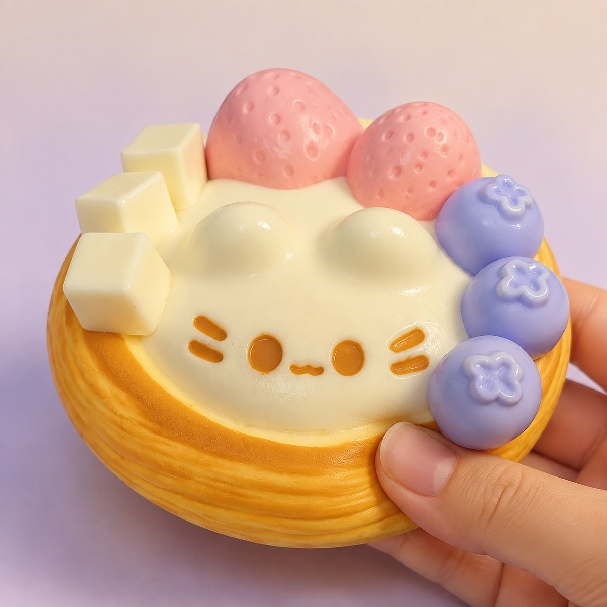 Hand pressing a cat egg-tart sensory squeeze toy