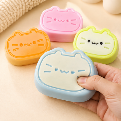 Hand pressing the blue cheese-cat sensory toy with all four colors shown