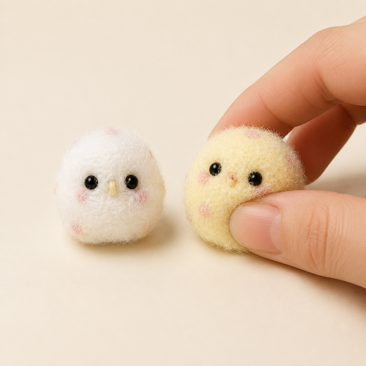 Hand pressing yellow fuzzy chicken beside white variant