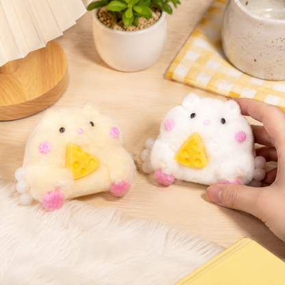 White and yellow chubby hamster squeeze toys on a cozy desk