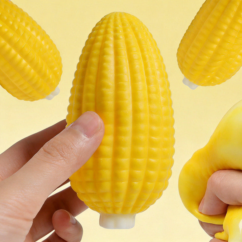 Hand squeezing the yellow corn squishy to show deformation