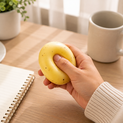 Hand squeezing a moldable potato sensory ball at a desk