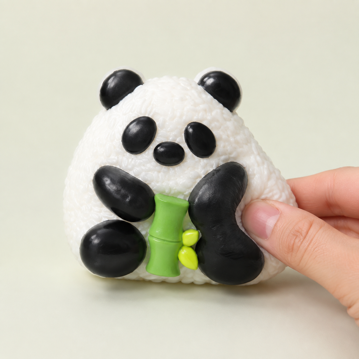 Hand pressing a panda rice-ball sensory squeeze toy