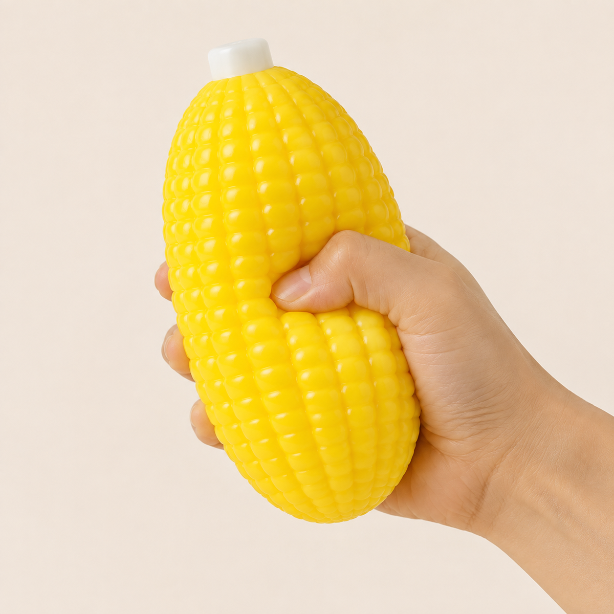 Yellow corn squishy toy being visibly squeezed